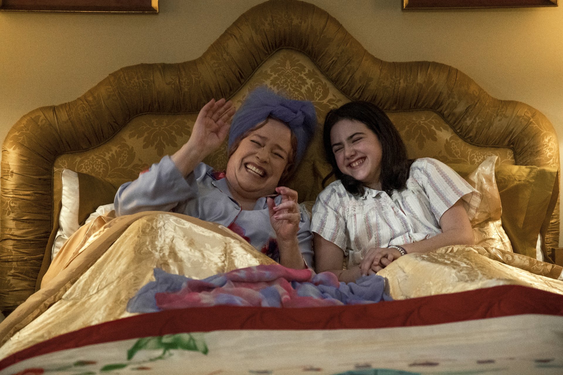 A heartwarming scene from the movie Are You There God? It's Me, Margaret. featuring a mother and daughter laughing together in bed, creating a cozy atmosphere. HD desktop wallpaper available.