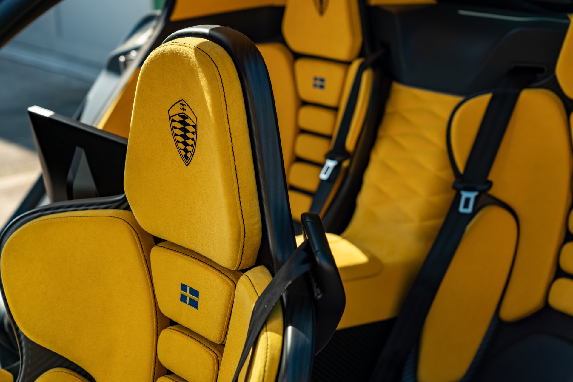High-definition wallpaper showcasing the luxurious interior of a Koenigsegg Gemera, featuring striking yellow upholstery and ergonomic design elements.