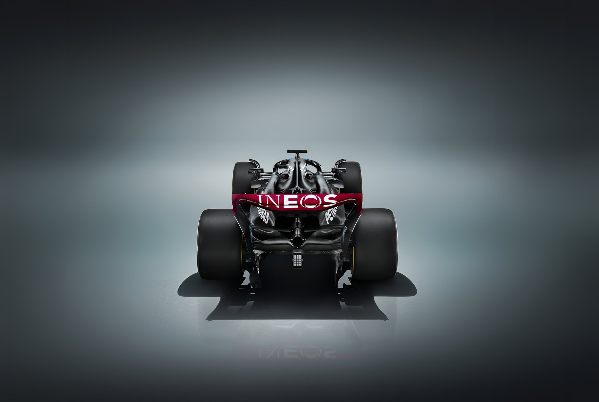 HD desktop wallpaper presenting a frontal view of a Mercedes W14 Formula 1 car, showcased against a sleek, dark gradient background.
