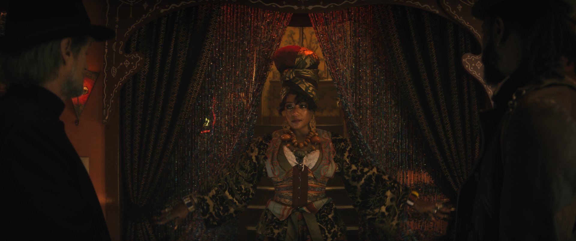 HD desktop wallpaper depicting a scene from the movie Haunted Mansion, featuring a character in a detailed, antique setting framed by heavy curtains.