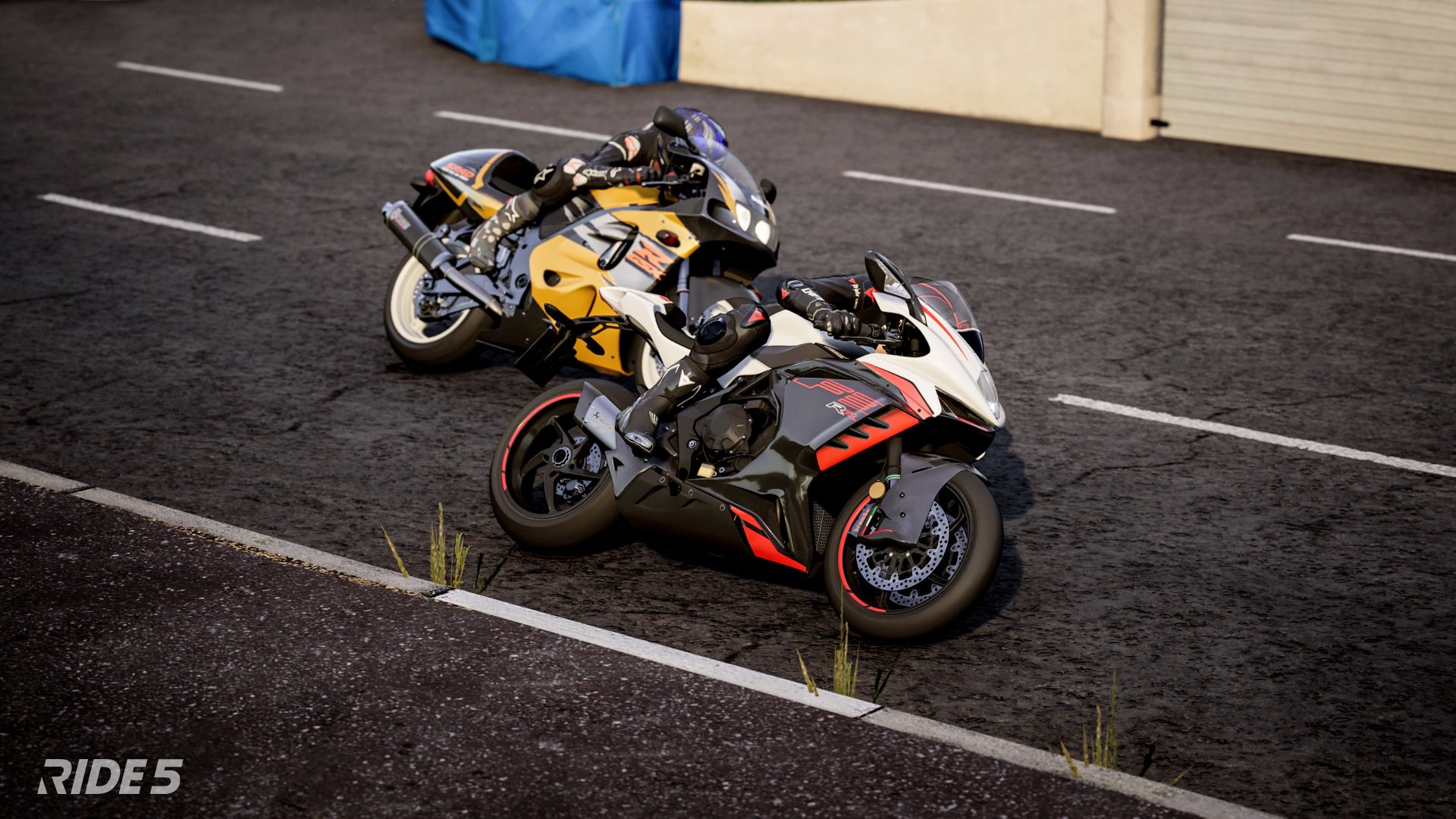 HD desktop wallpaper from the video game Ride 5 featuring two detailed sport motorcycles parked on a tarmac surface.