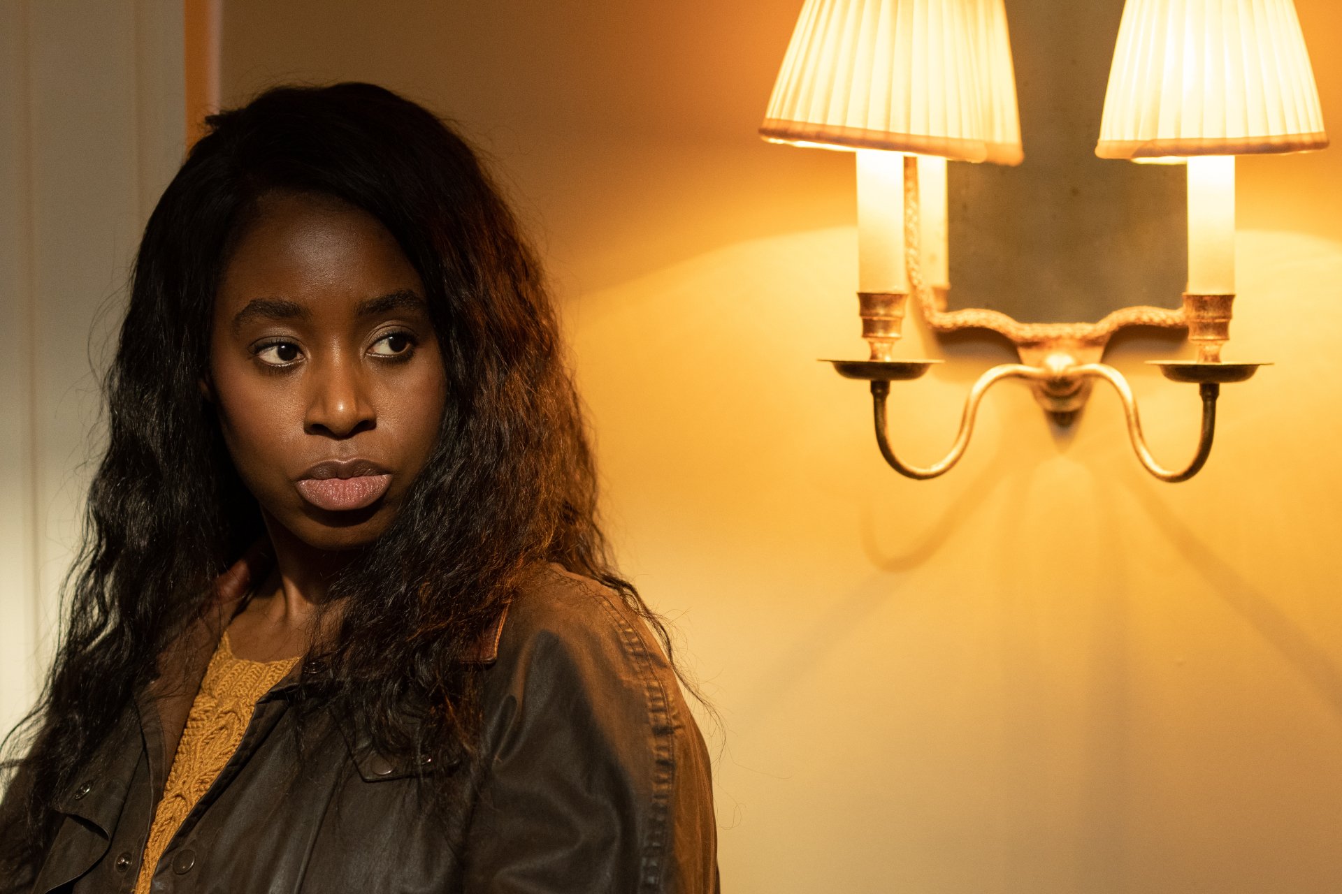 HD desktop wallpaper featuring an intense-looking person with a wall lamp background, tagged with Culprits.