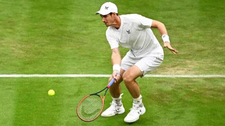 Andy Murray in action during Wimbledon 2023, showcasing his athleticism on the grass court as he prepares to strike the ball in this dynamic tennis scene.
