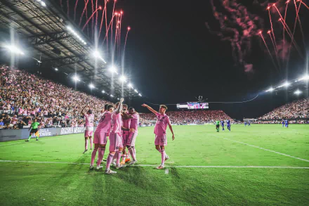 HD desktop wallpaper of Inter Miami CF team celebrating on the field with fireworks in the background and a packed stadium.