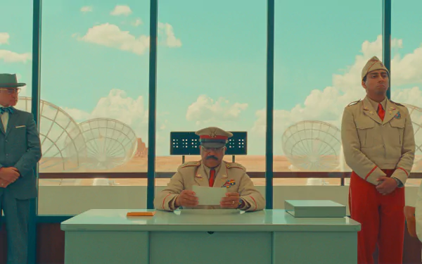 HD desktop wallpaper featuring a stylized scene from Asteroid City with three characters in uniform inside a room with large windows overlooking a desert landscape.