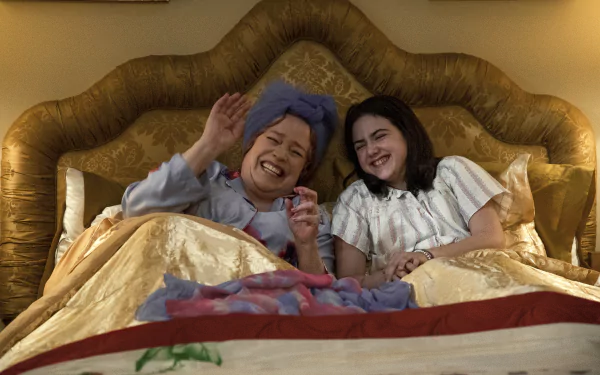 A heartwarming scene from the movie Are You There God? It's Me, Margaret. featuring a mother and daughter laughing together in bed, creating a cozy atmosphere. HD desktop wallpaper available.