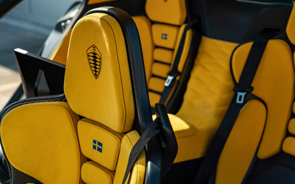 High-definition wallpaper showcasing the luxurious interior of a Koenigsegg Gemera, featuring striking yellow upholstery and ergonomic design elements.