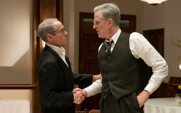 HD desktop wallpaper featuring two actors in character, shaking hands in a period-style setting, tagged with Oppenheimer, Robert Downey Jr., and Matthew Modine.