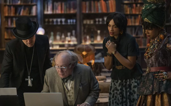 HD desktop wallpaper from the movie Haunted Mansion featuring four characters intently looking at a laptop in a library setting.