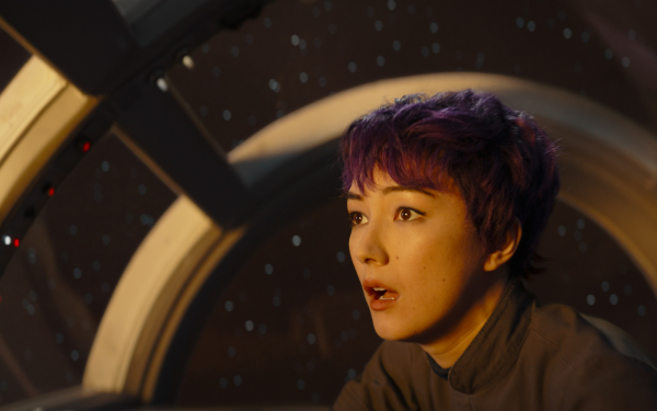 HD wallpaper of a woman with purple hair looking out of a spaceship window, reflecting themes from Ahsoka and Sabine Wren.