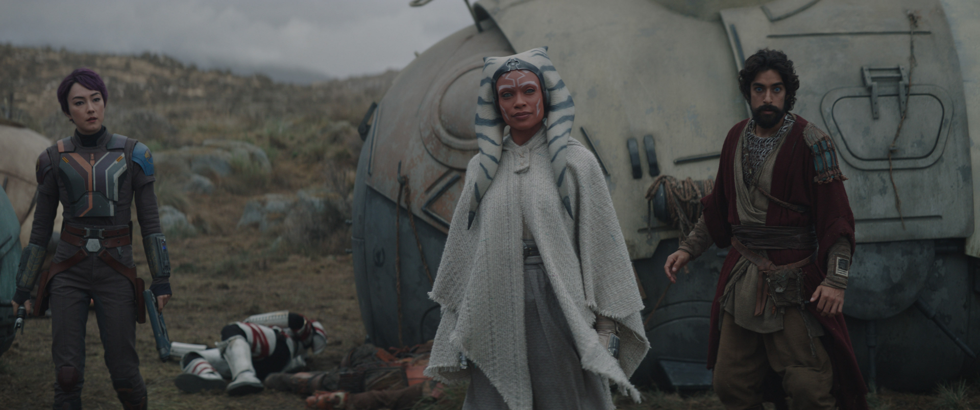 Ahsoka Tano stands prominently in the foreground with Ezra Bridger beside her, set against a dramatic backdrop from the Ahsoka (2023) TV series, featuring an atmospheric landscape.