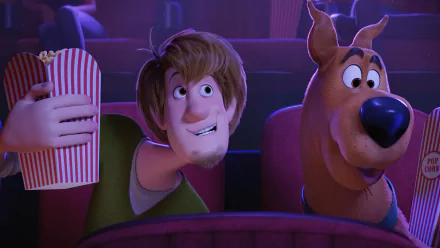 A vibrant HD wallpaper featuring Scooby-Doo and Shaggy Rogers in a movie theater, enjoying popcorn together. From the animated film Scoob!