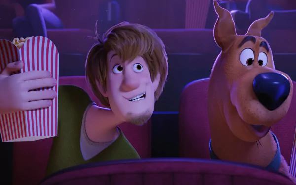 A vibrant HD wallpaper featuring Scooby-Doo and Shaggy Rogers in a movie theater, enjoying popcorn together. From the animated film Scoob!