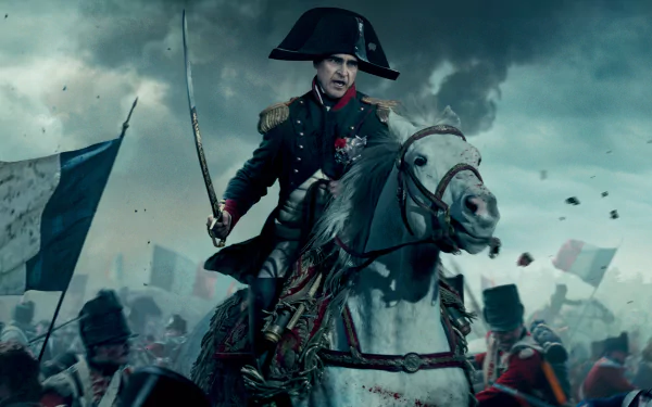 Napoleon movie scene: mounted on a white horse leading a smoky battlefield charge, flags and soldiers around — 2K Quad HD PC desktop wallpaper background.