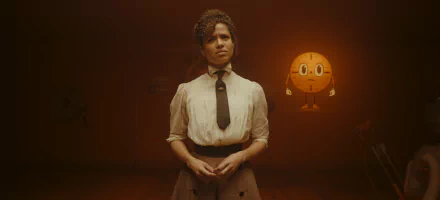 HD wallpaper featuring a character portrayed by Gugu Mbatha-Raw from the Loki series, standing in a moody, amber-lit room with a clock character in the background.