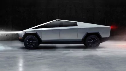 HD desktop wallpaper featuring the Tesla Cybertruck with its futuristic design showcased in a showroom setting, highlighting the vehicle's angular lines and metallic finish.