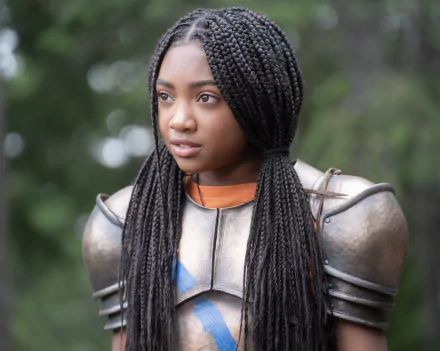 HD wallpaper of a character from the TV show Percy Jackson and the Olympians featuring a young female in armor with braided hair, set against a blurred natural background.