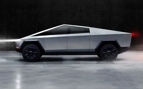 HD desktop wallpaper featuring the Tesla Cybertruck with its futuristic design showcased in a showroom setting, highlighting the vehicle's angular lines and metallic finish.