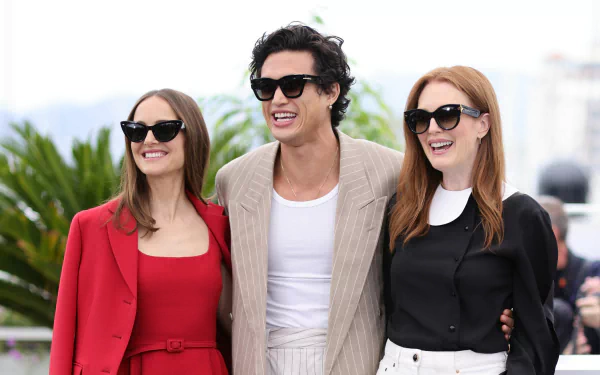 A vibrant HD wallpaper featuring the cast of the movie May December, showcasing three actors in stylish outfits and sunglasses, posing against a sunny background.