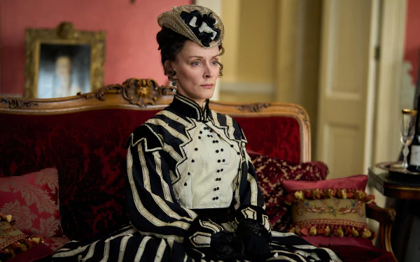 Elegant character from Belgravia: The Next Chapter dressed in Victorian attire sitting on an antique sofa with luxurious red background – HD desktop wallpaper.