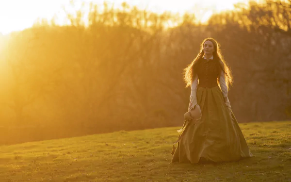 A character from the TV show Belgravia: The Next Chapter stands in a sunlit field, wearing a flowing gown, capturing a moment of tranquility at sunset. HD desktop wallpaper.