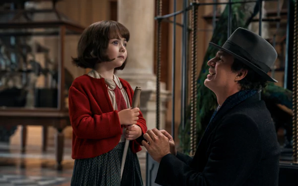 HD desktop wallpaper featuring a scene from the TV show All the Light We Cannot See with a young girl and an adult in a hat sharing a moment.