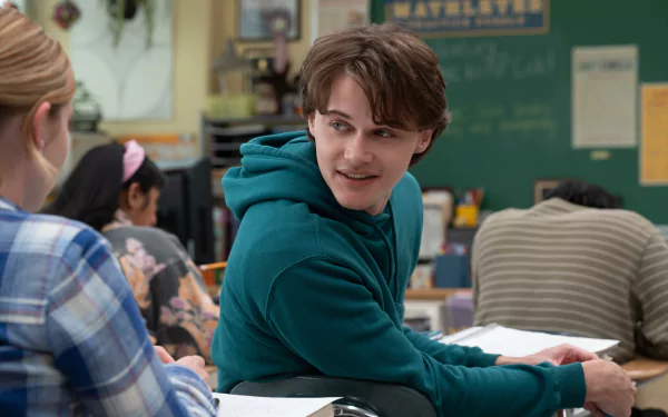 A high-definition desktop wallpaper featuring a scene from the 2024 movie Mean Girls with a character smiling and turning in a classroom setting.