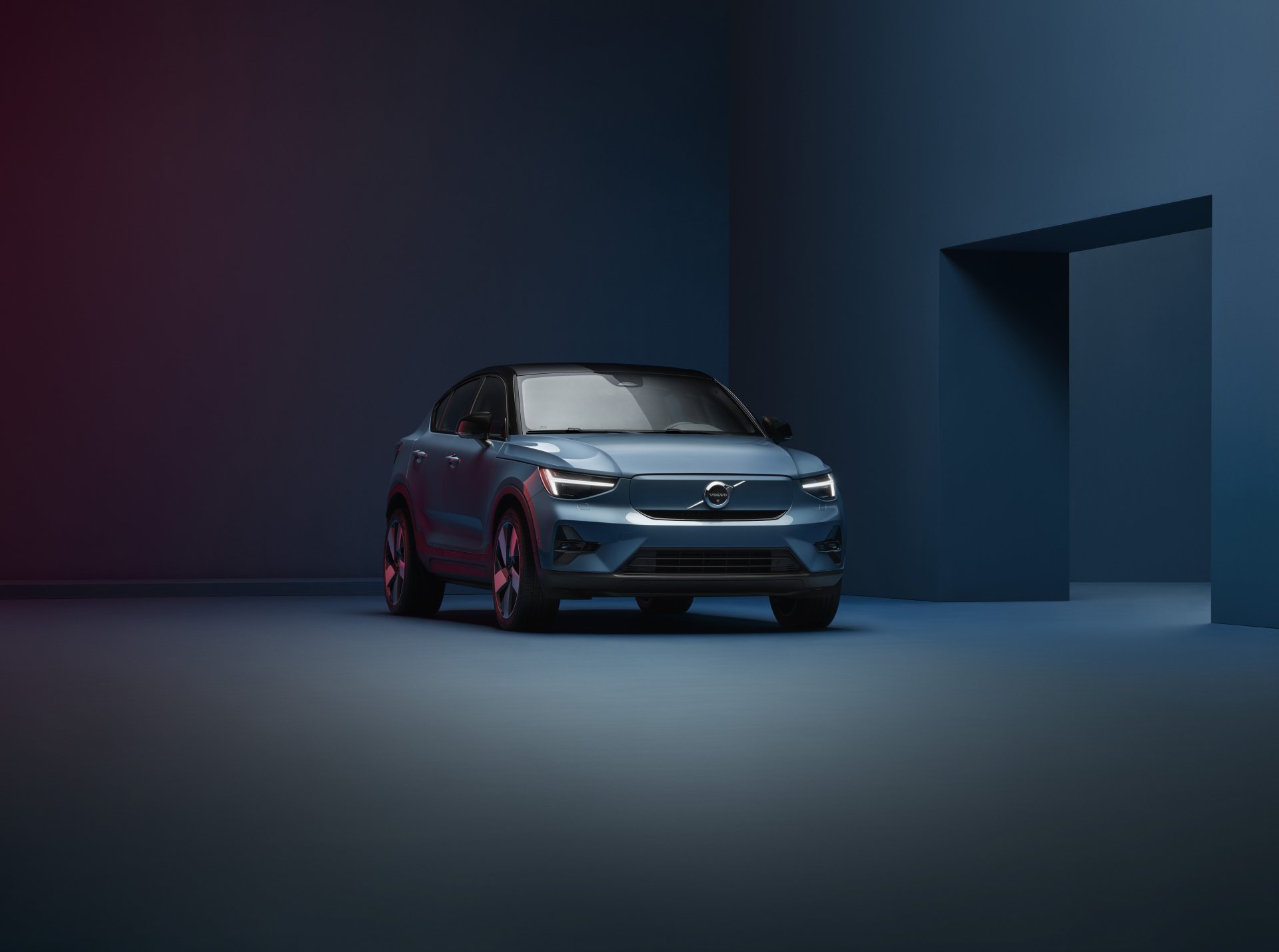 Volvo C40 car showcased as a stylish HD desktop wallpaper with a dark, artistic background.