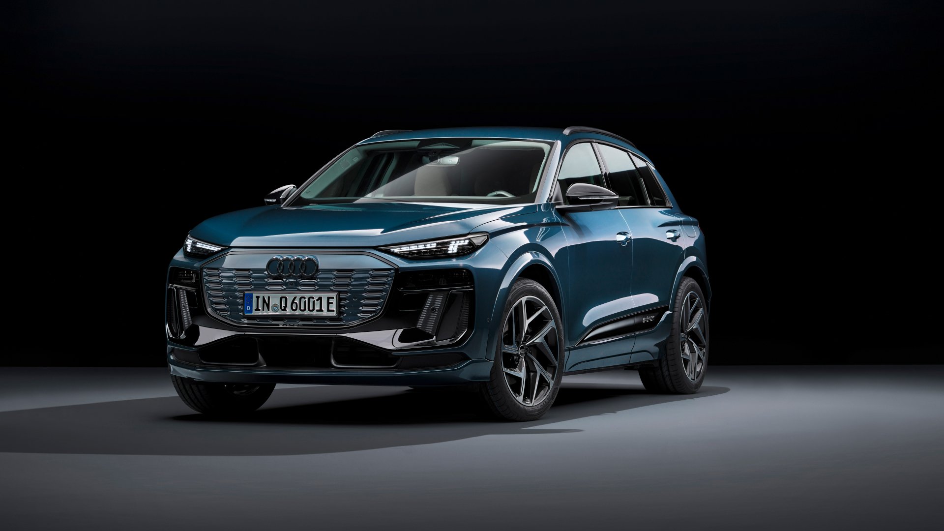 Audi Q6 e-tron electric SUV on display as an HD desktop wallpaper, showcasing its sleek design and modern electric vehicle aesthetics with a dark background.