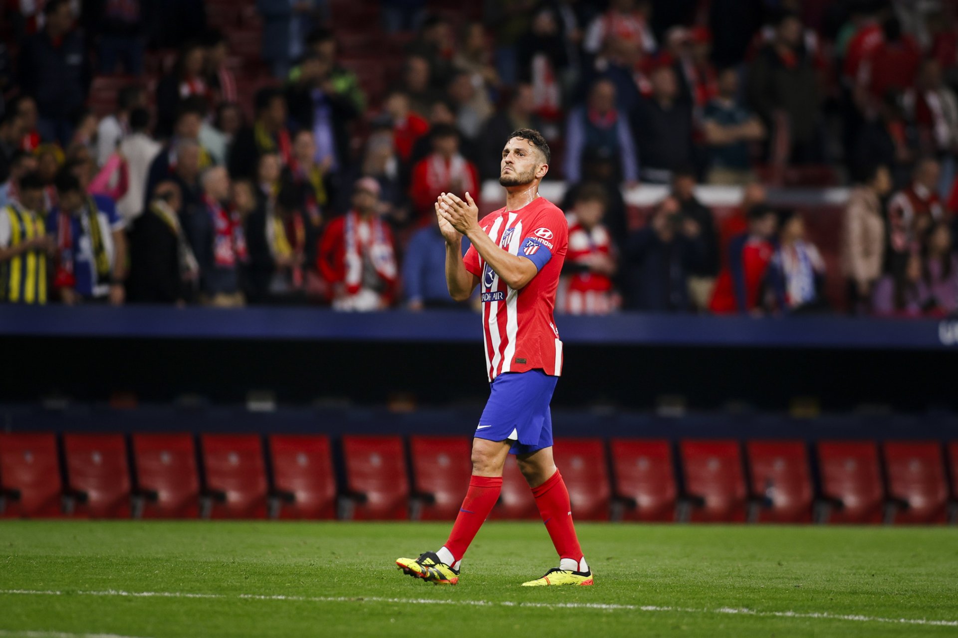 Atlético Madrid soccer player clapping on the field in a high-definition desktop wallpaper with stadium background.