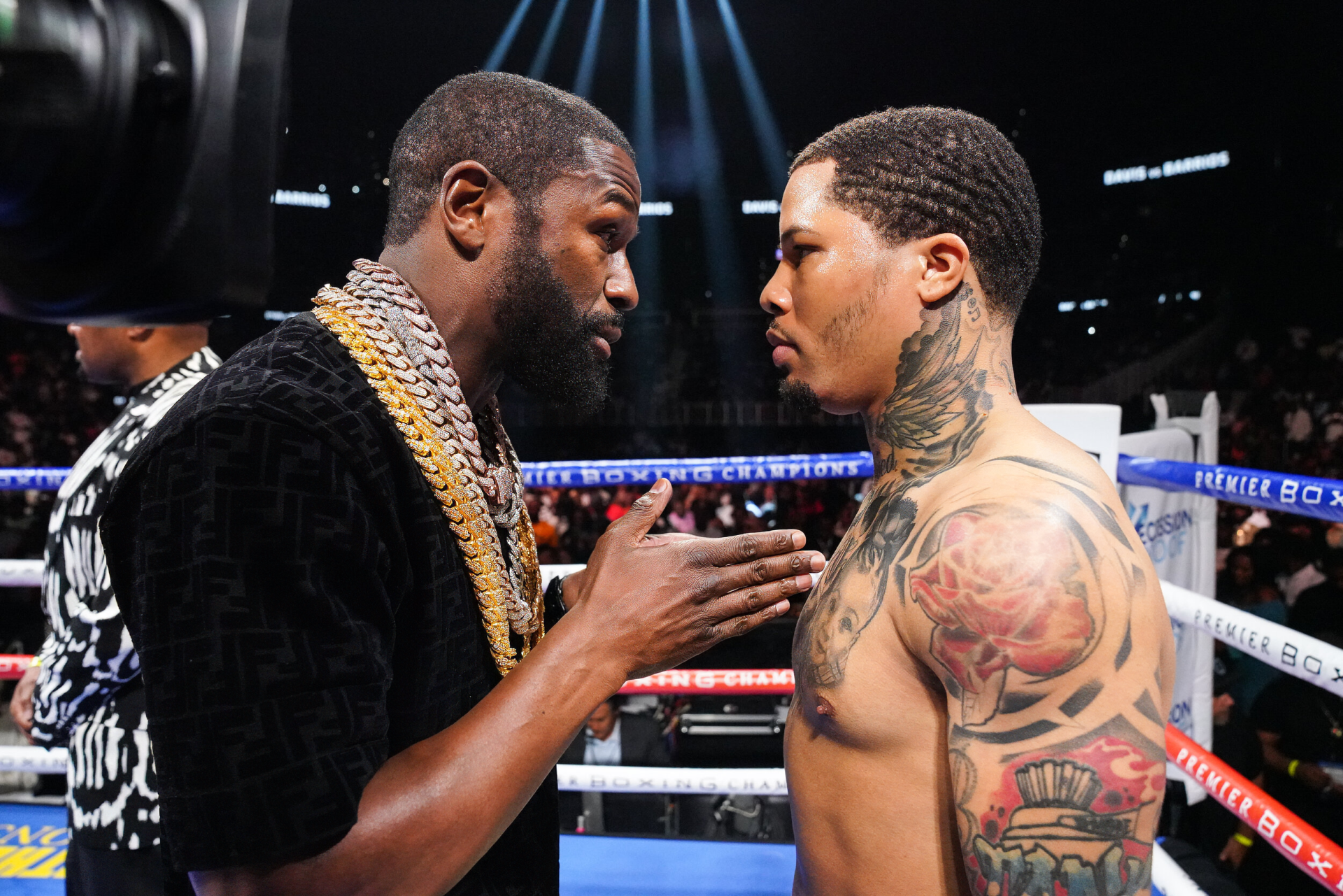 HD wallpaper of two boxers in a tense face-off inside a boxing ring, with one boxer heavily tattooed, indicative of a pre-fight promotional event.