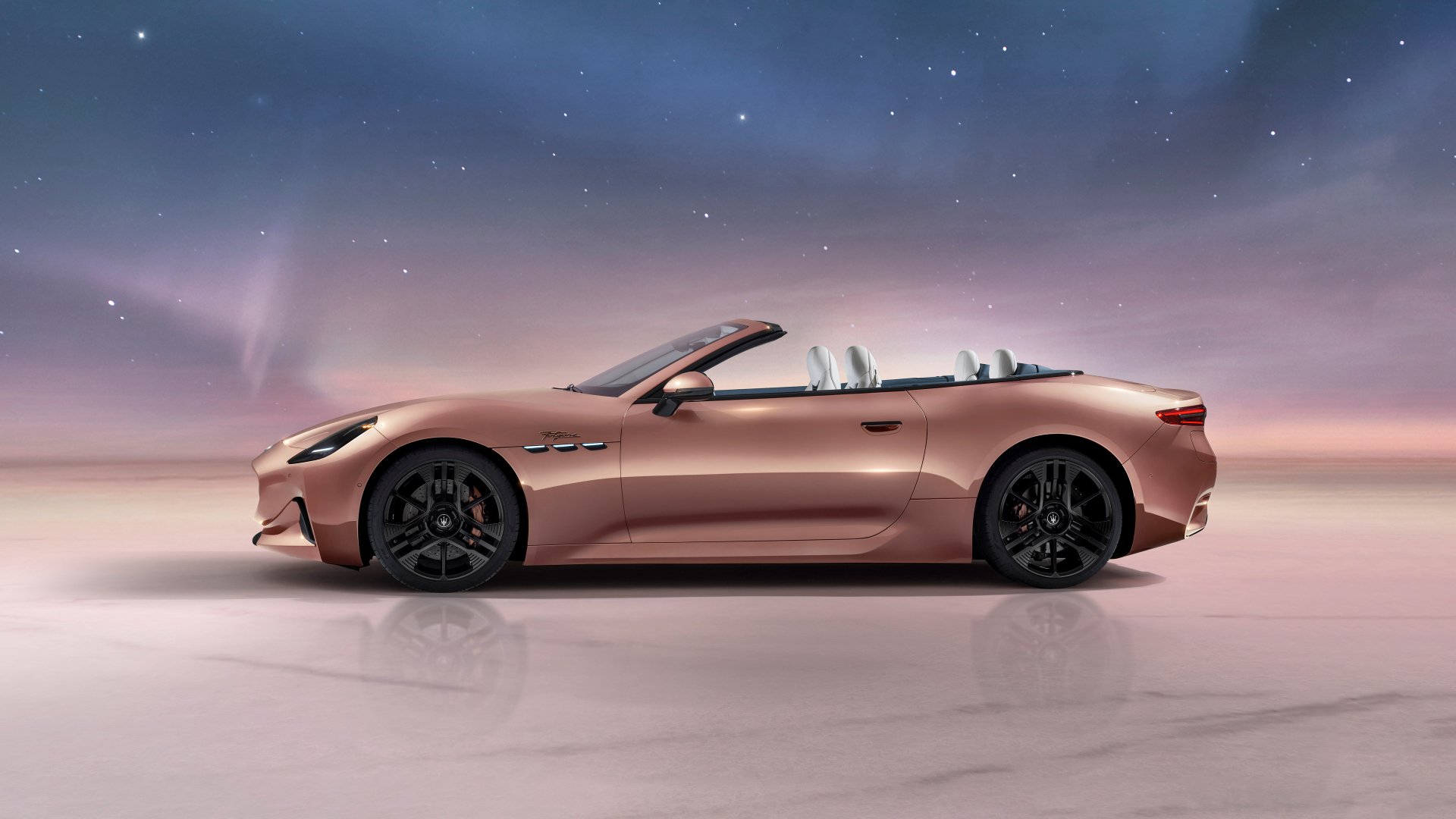 HD wallpaper featuring a Maserati GranCabrio car in a convertible model, parked with its top down, set against a soft dusk sky with subtle northern lights.
