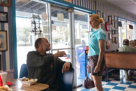 HD desktop wallpaper featuring a scene from the movie Suncoast (2024) with two characters in a diner.