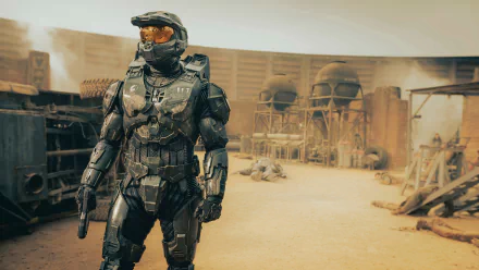 HD desktop wallpaper featuring a character in futuristic armor from the Halo TV show set against a dusty, sci-fi battlefield backdrop.