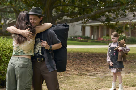 A scene from the movie Imaginary (2024), featuring a heartfelt embrace between a man and woman, while a young girl stands alone, holding a teddy bear in a peaceful outdoor setting.