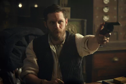 HD wallpaper featuring a character from the TV show Peaky Blinders, depicted in a dramatic scene holding a gun, evoking the intense atmosphere of the series.