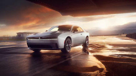 A sleek Dodge Charger Daytona shines in an HD wallpaper, showcasing its bold design against a dramatic sunset backdrop on a wet surface.