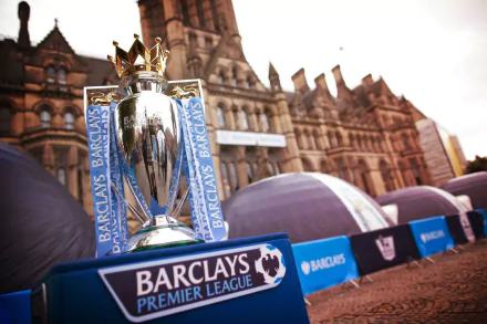 Premier League trophy on display with Barclays branding in front of an iconic building, available as HD soccer desktop wallpaper and background.
