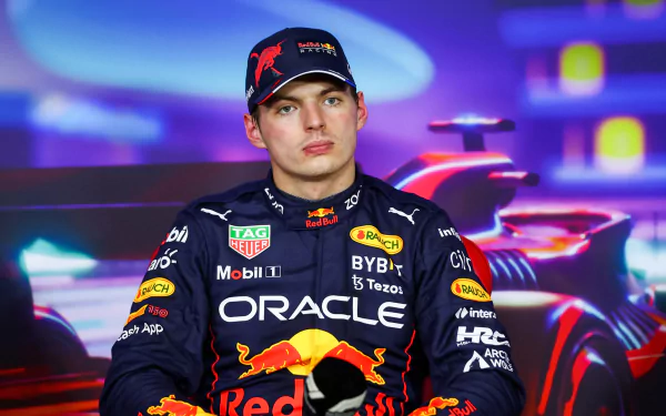 HD desktop wallpaper featuring F1 driver Max Verstappen in a Red Bull racing suit, poised against a vibrant racing-themed backdrop.