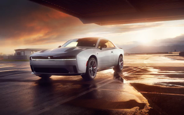 A sleek Dodge Charger Daytona shines in an HD wallpaper, showcasing its bold design against a dramatic sunset backdrop on a wet surface.