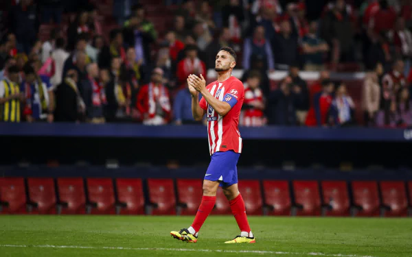 Atlético Madrid soccer player clapping on the field in a high-definition desktop wallpaper with stadium background.