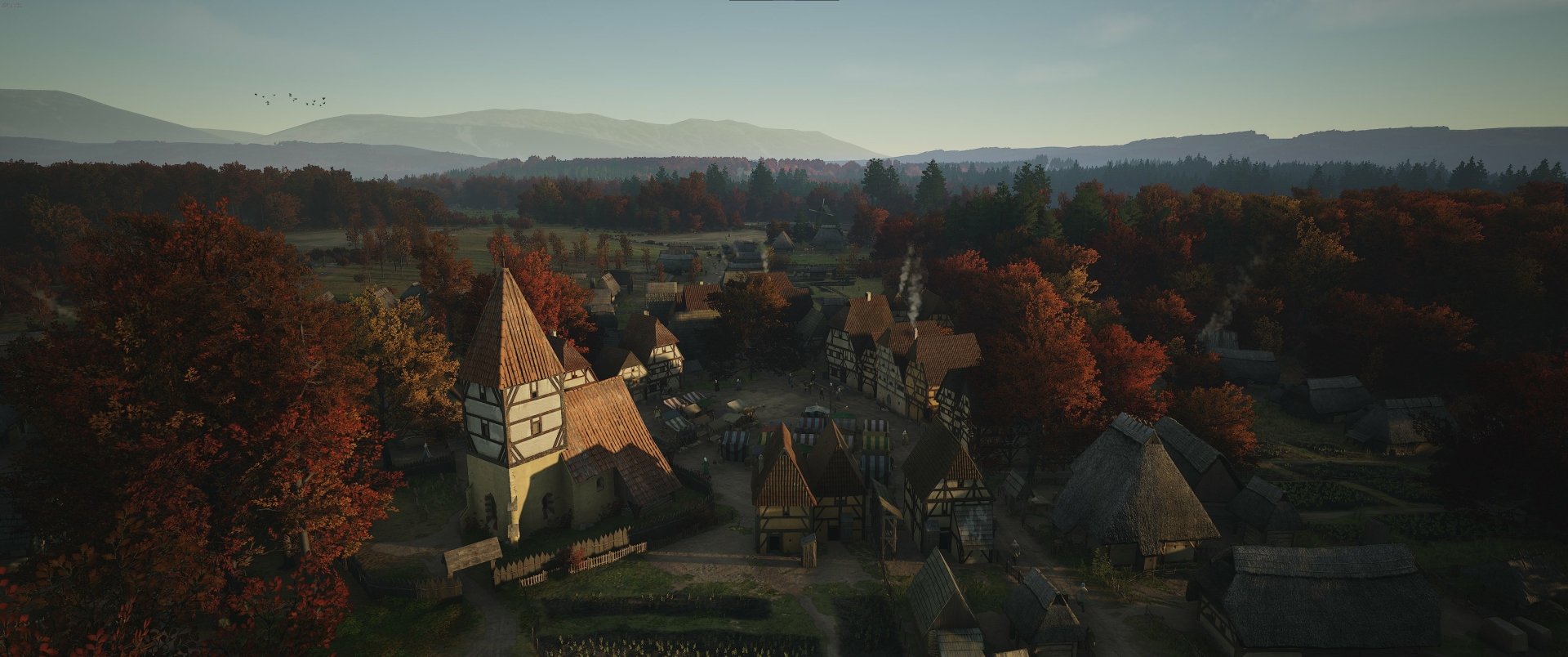 HD desktop wallpaper from the video game Manor Lords featuring an autumnal medieval village with rustic houses and towering trees.
