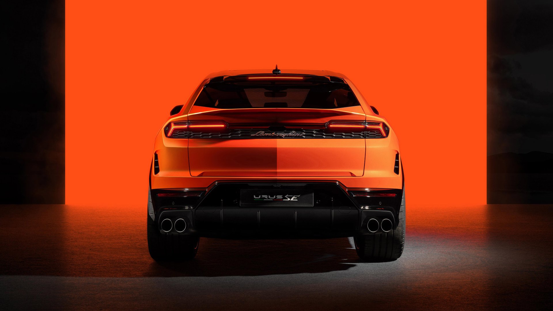 HD desktop wallpaper of a Lamborghini Urus set against a vibrant orange background, highlighting the car's sleek rear silhouette and distinctive taillights.