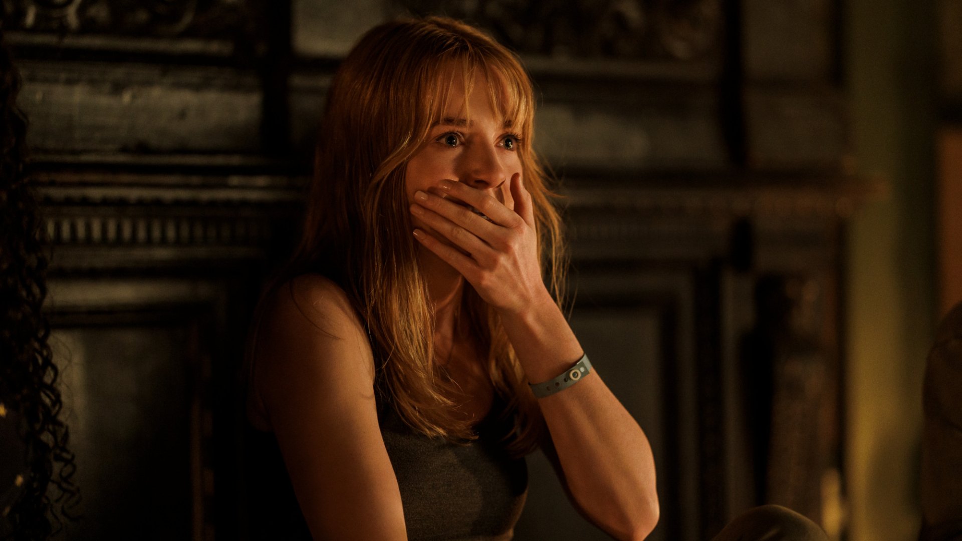 HD desktop wallpaper from the movie Tarot (2024) featuring a shocked woman with her hand over her mouth, in a dimly lit room.