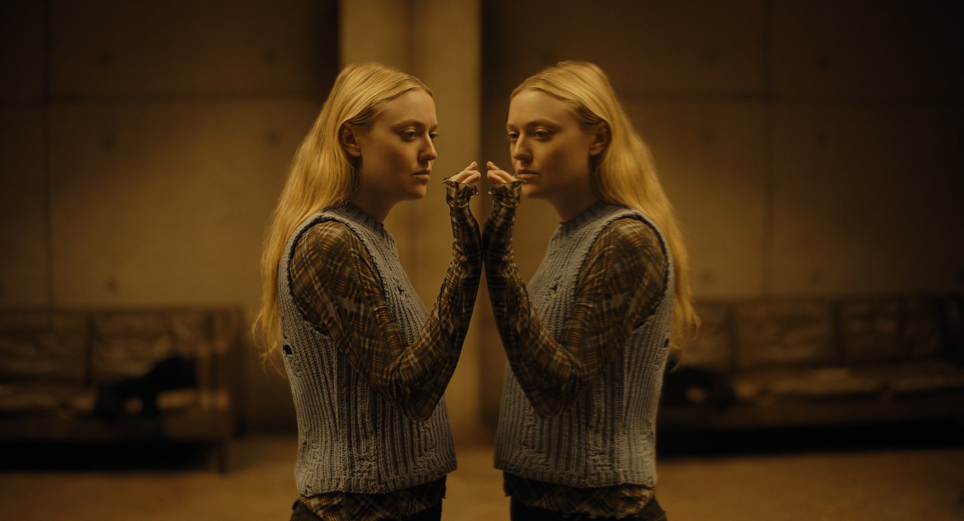 HD wallpaper featuring Dakota Fanning in The Watchers (2024). The image showcases a symmetrical reflection of her, creating a captivating visual. The background has a warm, dimly lit ambiance.