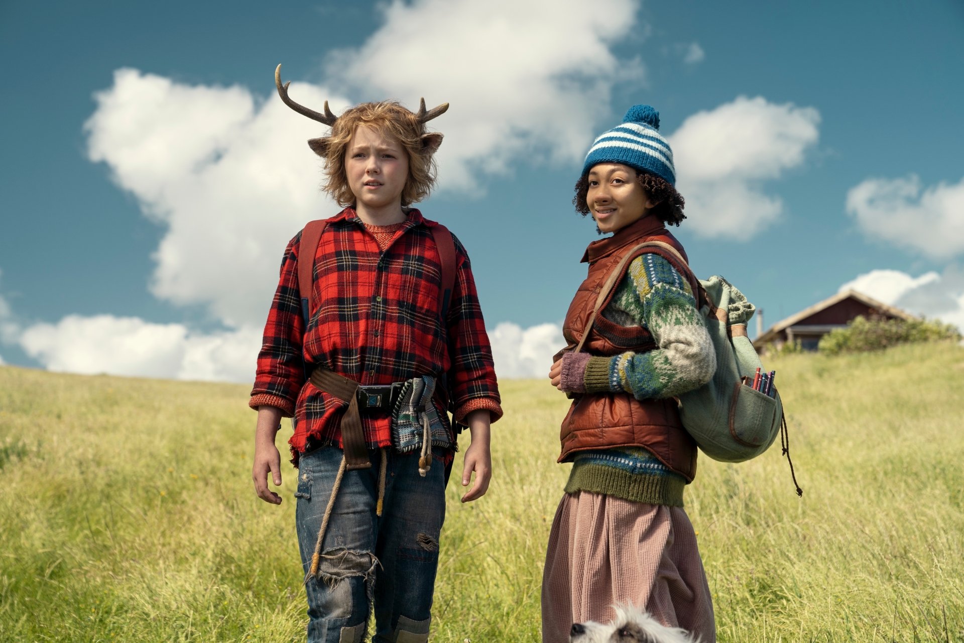 HD desktop wallpaper of the TV show Sweet Tooth featuring Gus, portrayed by Christian Convery, and a companion, standing in an open field with a house in the background.