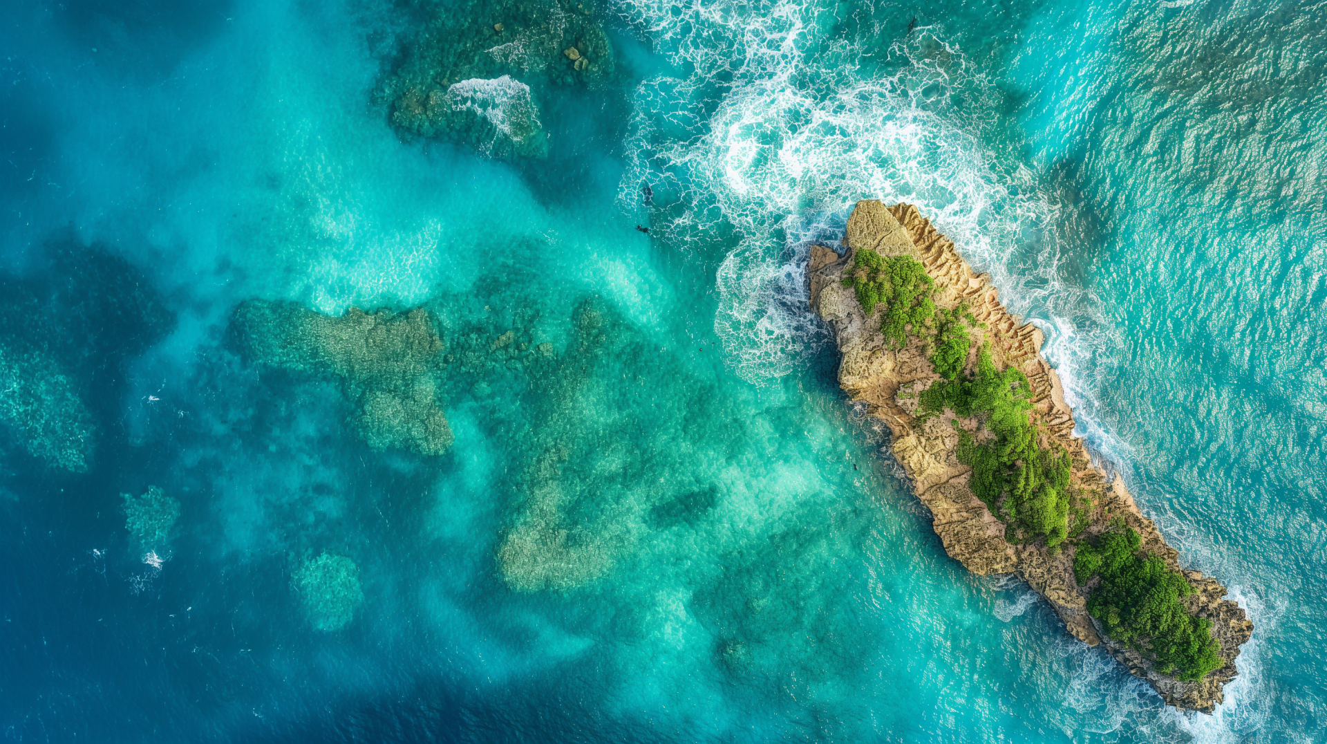 Aerial view of a vibrant ocean with turquoise waters surrounding a small lush island, captured in HD for a stunning PC desktop wallpaper.