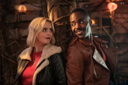 HD wallpaper from Doctor Who (2023) featuring Ncuti Gatwa and a female costar in a warmly lit, rustic setting.