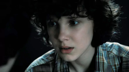 Close-up of Eleven from Stranger Things, portrayed by Millie Bobby Brown, captured in 8K Ultra HD as a detailed PC desktop wallpaper.