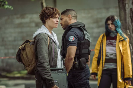 HD desktop wallpaper depicting a scene from the movie Under Paris, featuring intense interaction between three characters, one of whom is a police officer wearing a vest.